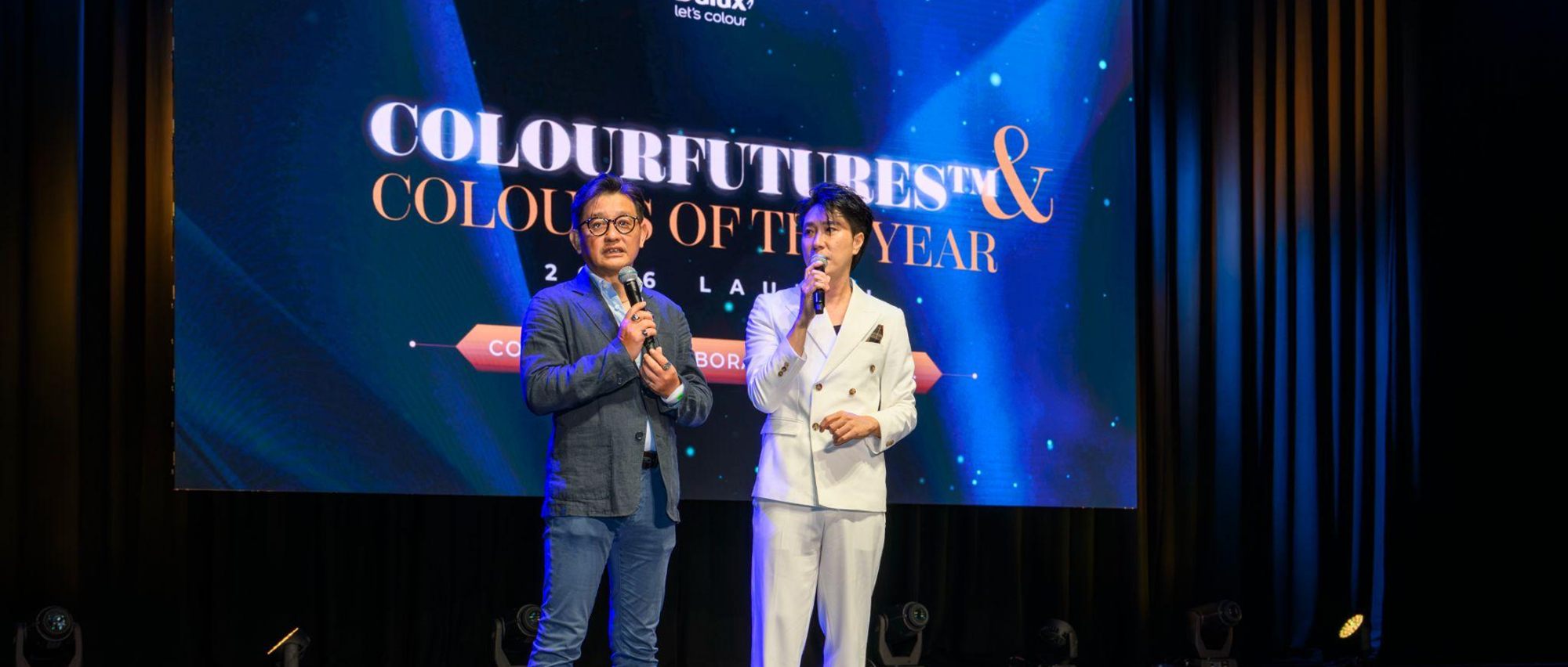 Two presenters on stage at the ColourFutures and Colours of the Year 2026 Launch, the launch title filling the screen behind them