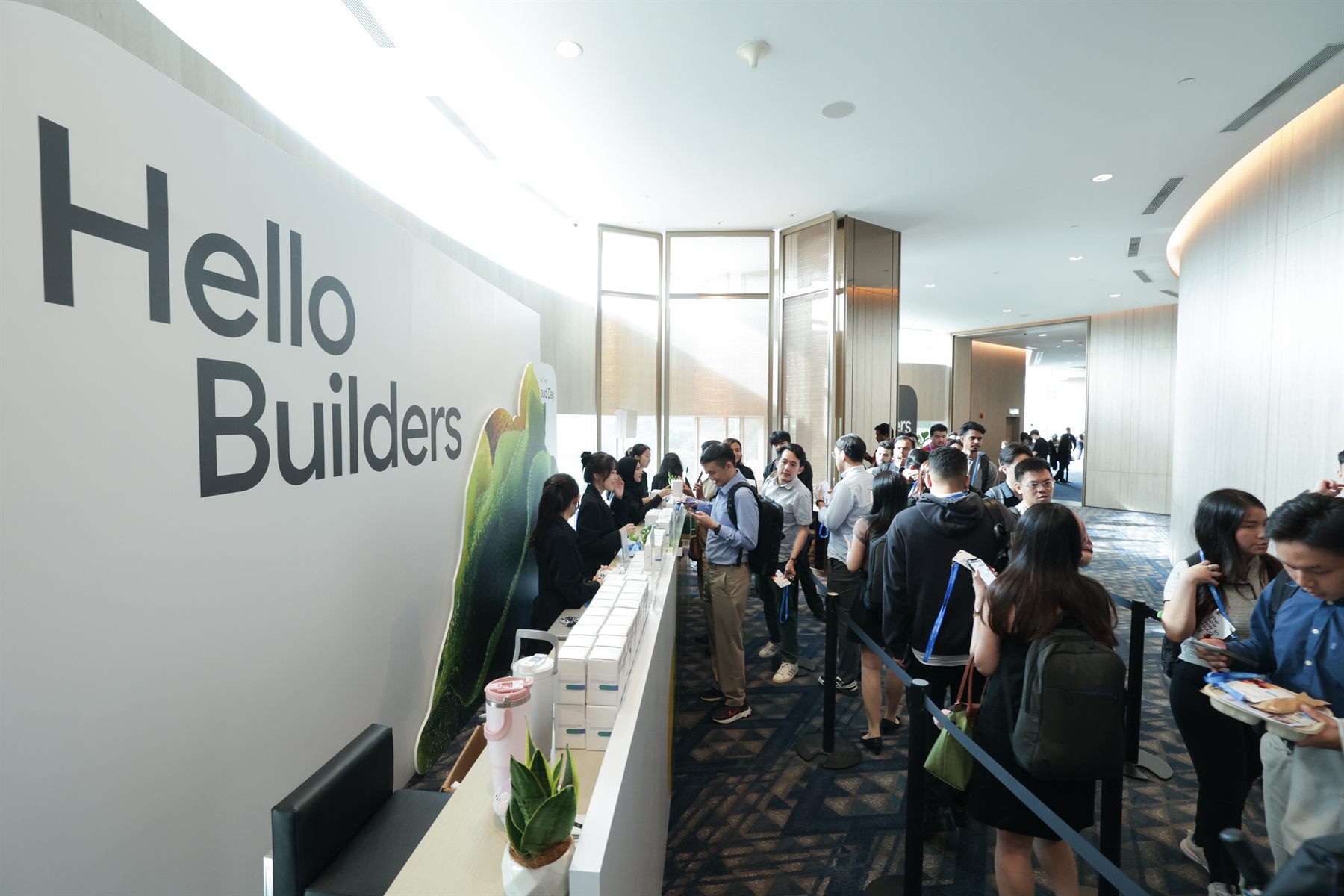 Guests gathering at the Hello Builders counter, daylight from the windows behind